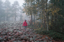 Frau wandert durch Steinfeld im Skuleskogen Nationalpark im Osten von Schweden