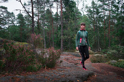 Frau wandert durch Wald im Tyresta Nationalpark in Schweden\n