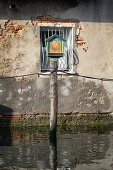 Blick auf einen Jesus Schrein auf einen Holzpfahl im Kanal von Chioggia, Chioggia, Veneto, Venetien, Italien, Europa