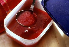 Strawberry Puree in a Plastic Conatiner with Ladle