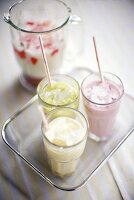 Drei Milchshakes mit Früchten auf Tablett