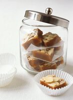 Toffee and almond slices in a jar and in front of it