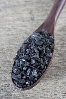 Black salt on wooden spoon