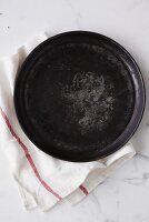 Round baking tray on tea towel (overhead view)