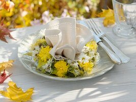 Herbstliches Gedeck mit Stoffserviette und Blumenkranz