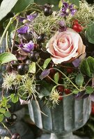 Arrangement of black rose hips, clematis and a rose