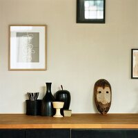 Afrikanische Maske und Vasen auf einem Sideboard