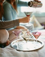 Pouring a cocktail out of a shaker into a martini glass