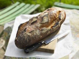 Bread and bread knife on a table in a garden