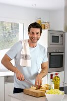 Man slicing bread in kitchen