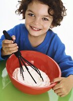 Boy whipping cream with whisk