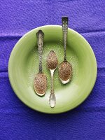 Three Spoon Madeleines with Powdered Sugar on Green Plate