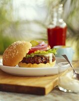 Cheeseburger mit Rucola, Zwiebel und Tomate