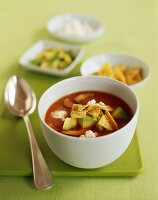 Bowl of Tortilla Soup with Avocado; Spoon; Tortilla Chips