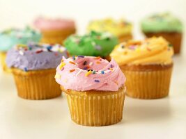 Mehrere Cupcakes mit bunten Glasuren und Zuckerstreuseln