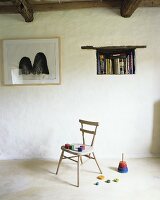 Colorful wooden blocks on an old wooden chair, a throwing game, books in a wall niche and a picture on the wall