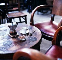 An espresso jug, cups and brown sugar on a round table