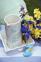 Posy of spring flowers next to jug