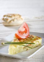 Potato tortilla with chives and wedge of tomato