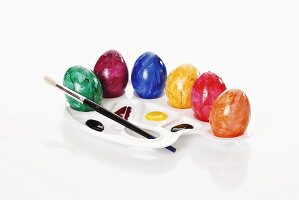 Coloured Easter eggs with paints and paintbrush