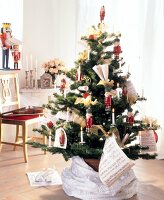 Christmas tree decorated with lit candles, soldier figurines and music sheets