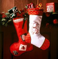Red and white Christmas stockings hanging on wooden wall