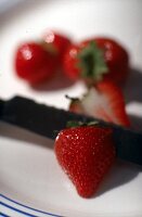Erdbeeren und Messer auf einem Teller - close up