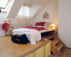 Bed with storage and illuminated lamp on pedestal