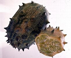 Eine ganze und eine geteilte Kiwano (Hornmelone)