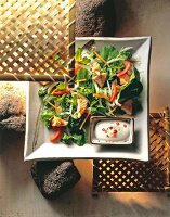 Salmon salad with chilli sauce on plate, overhead view