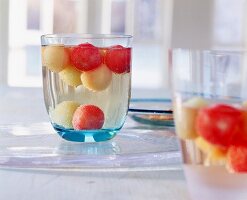 Maibowle-Glas mit fruchtigem Inhalt, Kugeln von Melonen