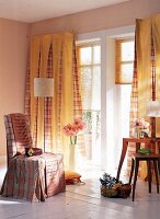 Raum mit Vorhängen und Sesselüberwurf mit Karomuster und in Gelb