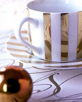 Kaffeetasse aus weißem Porzellan mit goldenem Blockstreifendekor
