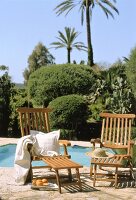 Zwei Deckchairs stehen vor dem Pool mediterane Vegetation im Hintergrund