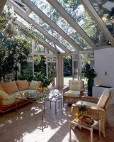 Seaweed sofa, cotto tiles and green plants in open room with glass doors