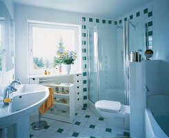 Interior of tiled bathroom with shower stall, bath tub and wash basin