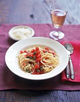 Spaghetti mit Tomaten-Kapern-Sauce auf weißem Teller