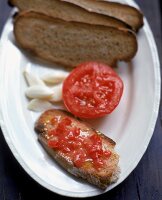 Bruschetta - Bauernbrot, Knoblauch und Tomate auf weißem Teller
