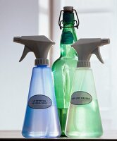 Close-up of three spray bottles with vinegar, alcohol and water