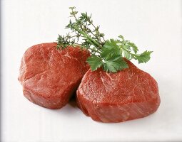 Zwei rohe Rindersteaks, mit Kräutern dekoriert