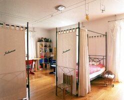 Zwei Kinderbetten im Raum mit Metall -konstruktion und Vorhängen