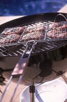 Grill-Basket mit sechs Burger auf dem Grill