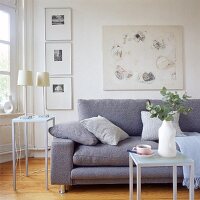Ein Bild über dem Sofa wird durch eine senkrechte Bilderreihe ergänzt