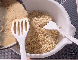 Die Carbonara-Sauce wird unter die Spaghetti gemengt