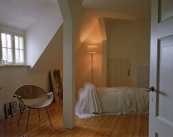 Schlafzimmer mit Holzboden und Dachschrägen, Stuhl, kleine Fenster