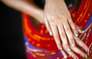 Close-up of woman with gold painted fingernails