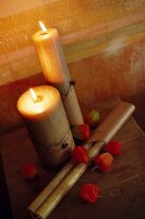 Close-up of lit beeswax candles with physalis