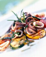 Close-up of marinated grilled vegetables with fried calamari on plate