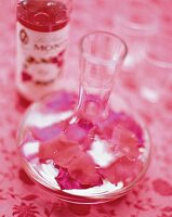 Rosensirup in einer Karaffe mit Rosenblättern,close up