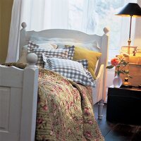 Weisses Bauernbett mit Decke im Quilt-Stil und diverse Kissen
